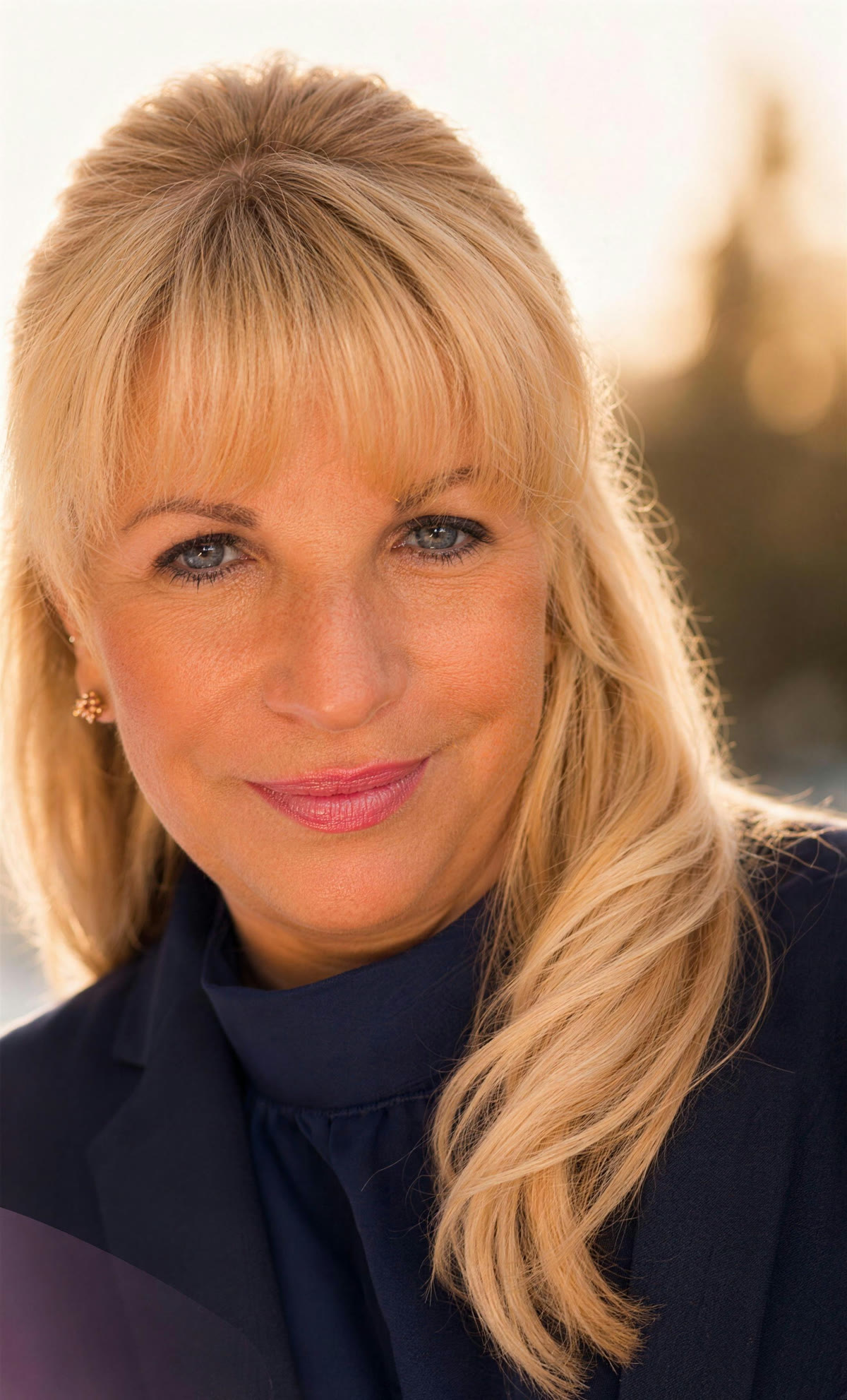 Heike Stumpenhusen, freie Trauerrednerin bei Berlin, im warmen Abendlicht, dunkelblaue Bluse, lächelnd.